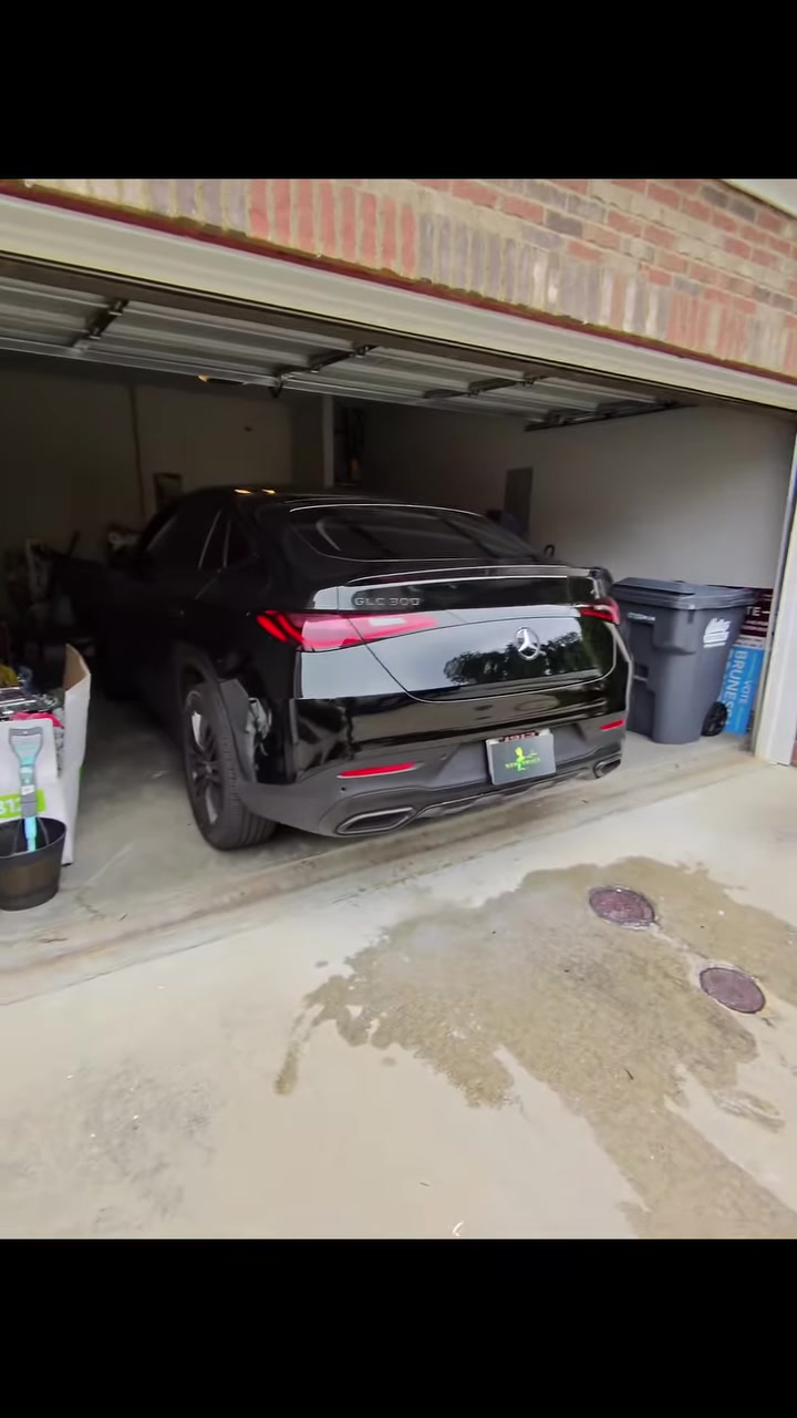 Black Mercedes at a residential garage opening after trunk and rear bumper work